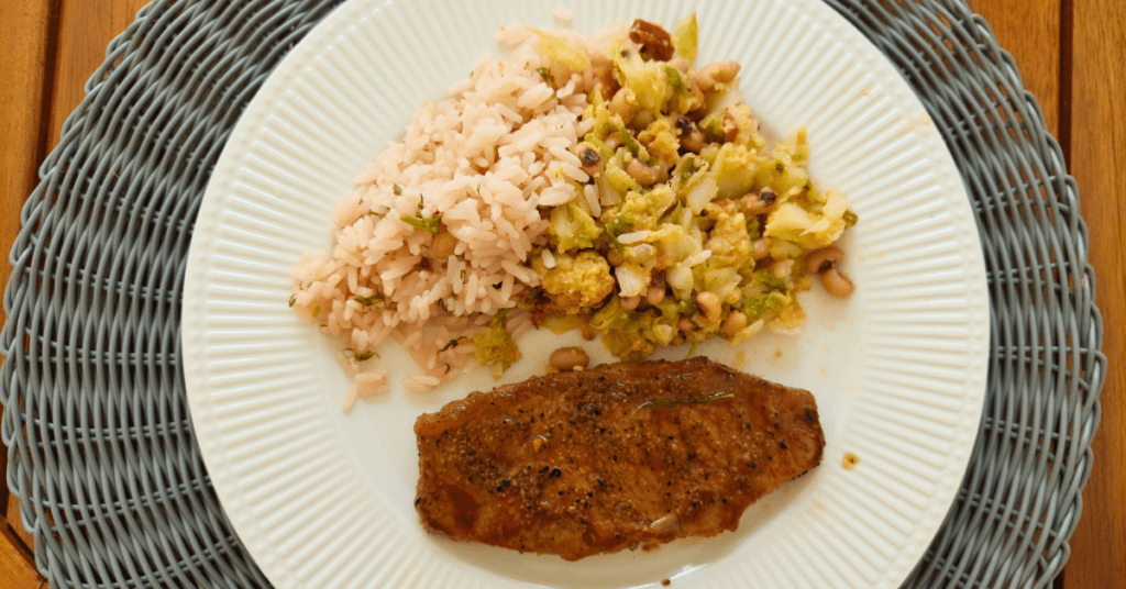 Deliciosas ideias do dia Bife de vitela na frigideira com manteiga, arroz de coentros e migas.